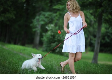 Young Blond Woman Walking With Puppy