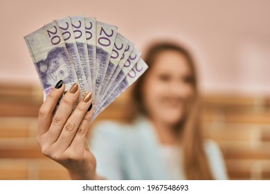 Young Blonde Businesswoman Smiling Happy Holding Sweden Krona Banknotes At The City.