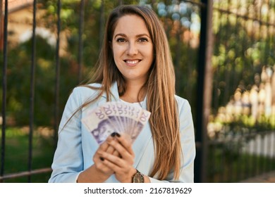 Young Blonde Businesswoman Smiling Happy Holding Sweden Krona Banknotes At The City.