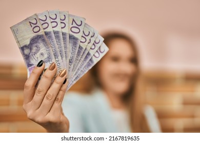 Young Blonde Businesswoman Smiling Happy Holding Sweden Krona Banknotes At The City.