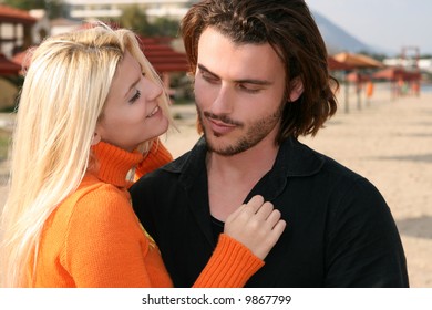 Young blonde couple hugging each other outdoors