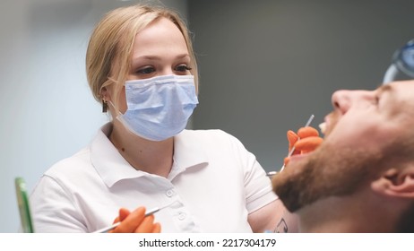 Young Blonde Doctor Treats Young Man's Teeth.