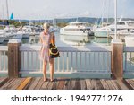 A young blonde female tourist visits Crystalbrook Superyacht Marina on a summer day in Port Douglas, Queensland.