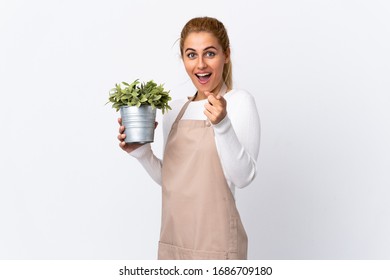 Young Blonde Gardener Woman Girl Holding A Plant Over Isolated White Background Points Finger At You