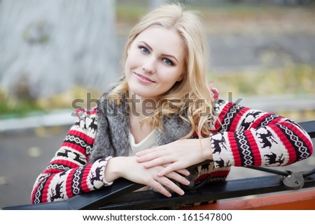 young blonde girl in cardigan with a traditional Celtic ornament