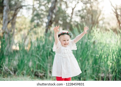 Young Blonde Girl Celebrating Australian Summer Christmas Outdoors Wearing White And Red Festive Colours And A Holly Berry Wreath Flower Crown