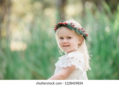 Young Blonde Girl Celebrating Australian Summer Christmas Outdoors Wearing White And Red Festive Colours And A Holly Berry Wreath Flower Crown