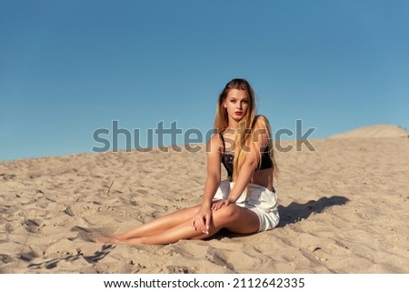 Similar – Young, long-legged woman sitting on the Baltic Sea beach