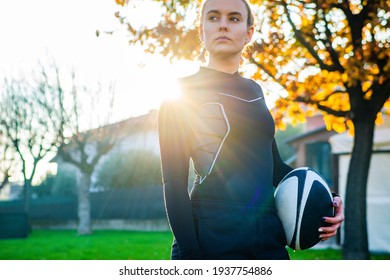 young blonde girl with pigtails at sunset concentrating before playing american football game. concept about sport, healthy life and workout - Powered by Shutterstock