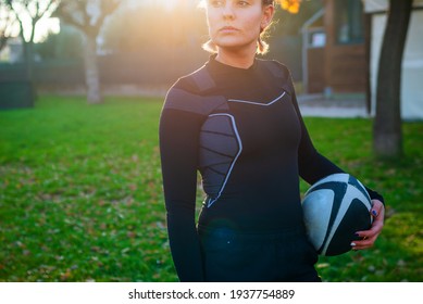 young blonde girl with pigtails at sunset concentrating before playing american football game. concept about sport, healthy life and workout - Powered by Shutterstock