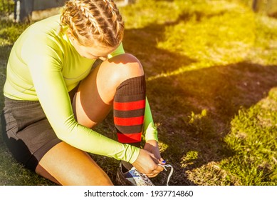 young blonde girl with pigtails tying her shoes before playing the game. Concept about sport, healthy life and workout. - Powered by Shutterstock