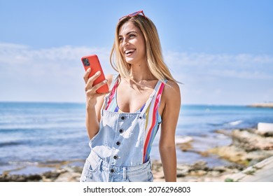 Young blonde girl smiling happy using smartphone at the beach. - Powered by Shutterstock