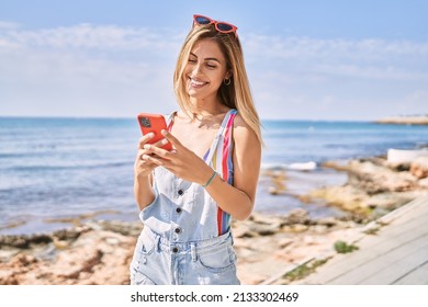 Young blonde girl smiling happy using smartphone at the beach. - Powered by Shutterstock