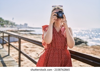 Young blonde girl smiling happy using camera at the beach - Powered by Shutterstock