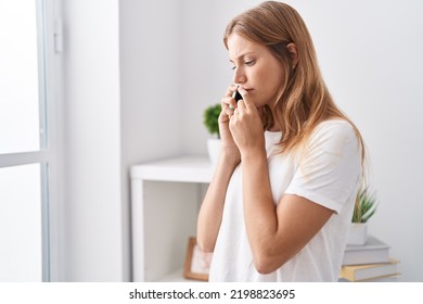 Young blonde girl talking on smartphone with worried expression at home - Powered by Shutterstock