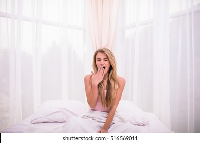 Young Blonde Girl Tired In Bed Yawn