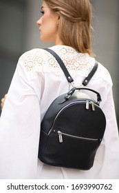 Young Blonde Girl In White Blouse And White Pants Posing On The Street With Leather Backpack, Close Up And Full Body, No Logos