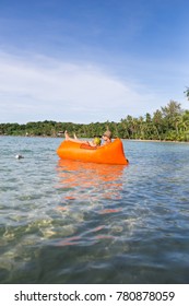 Young Blonde Man, Boy At The Beach With Lazy Inflatable Air Bed, Hammock, Couch Camping.  Lounger Sofa Beach Chair Portable Sleeping Bag Mattress. Relax, Vacation, Travel. Asia. Thailand