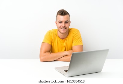 Young Blonde Man In A Table With A Laptop Laughing