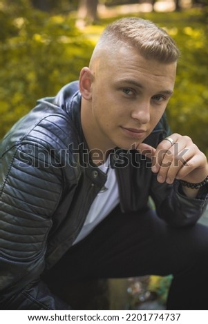 Similar – Stylish teenager sitting on a wooden bench on a city park