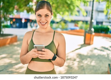 Young blonde sportswoman doing exercise using smartphone at the city. - Shutterstock ID 1875093247