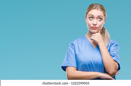 Young Blonde Surgeon Doctor Woman Wearing Medical Uniform Over Isolated Background With Hand On Chin Thinking About Question, Pensive Expression. Smiling With Thoughtful Face. Doubt Concept.