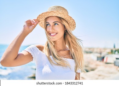 Young blonde tourist girl smiling happy looking to the side walking at the promenade.