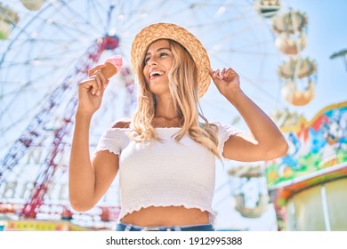 Young blonde tourist girl smiling happy eating ice cream at the fairground.
