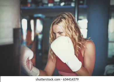 Young Blonde Woman Boxing To Heavy Bag In Gym Cinematic Style