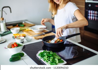 Young blonde woman cooking in the kitchen. Healthy Food. Dieting Concept. Healthy Lifestyle. Cooking At Home. Prepare Food