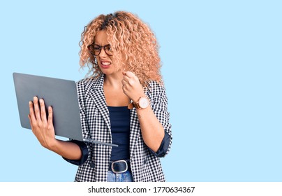 Young Blonde Woman With Curly Hair Working Using Laptop Annoyed And Frustrated Shouting With Anger, Yelling Crazy With Anger And Hand Raised 