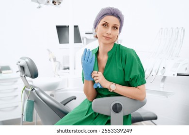 Young blonde woman dentist posing at modern dental cabinet next to dental chair. Pretty stomatologist at dental clinic - Powered by Shutterstock