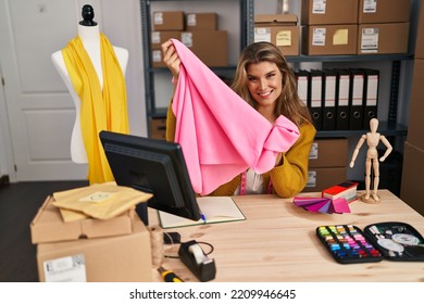 Young Blonde Woman Dressmaker Holding Cloth At Designer Studio