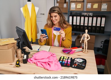 Young Blonde Woman Dressmaker Using Smartphone And Credit Card At Designer Studio