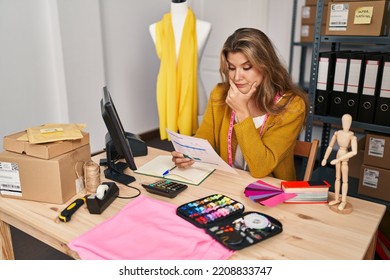 Young Blonde Woman Dressmaker Worried Reading Document At Designer Studio