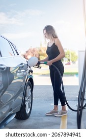 Young Blonde Woman Getting Gas In Her Car At A Gas Station