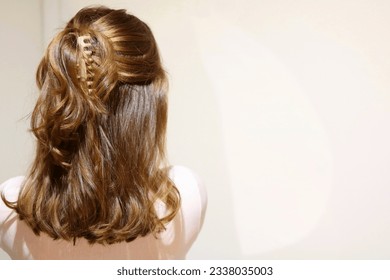 Young blonde woman with hair pulled half-up in beige claw clip. Trendy hairstyle. Messy, casual hairstyle. Copy space for text. Cool vintage filter.