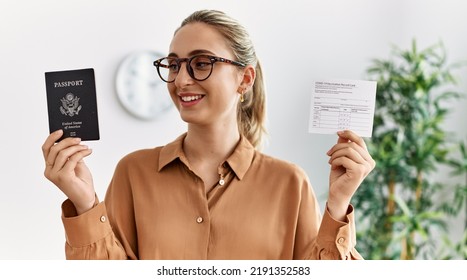 Young Blonde Woman Holding Covid Vaccination Record Card And Usa Passport At Waiting Room