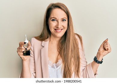 Young Blonde Woman Holding Keys Of New Home Screaming Proud, Celebrating Victory And Success Very Excited With Raised Arm 