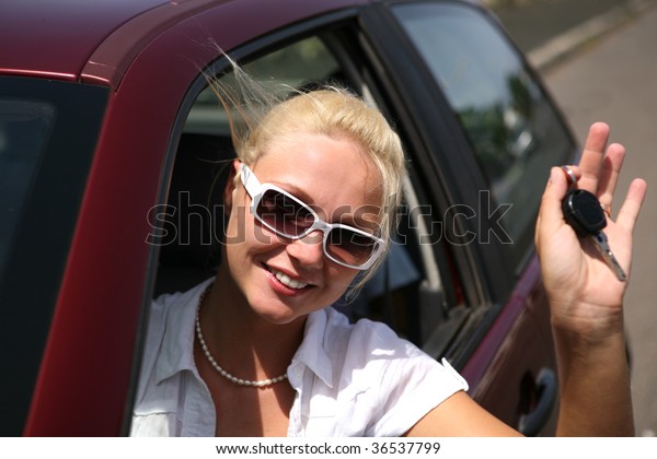 young blonde woman with\
keys in the car