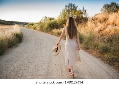 Young blonde woman with long hair happily walking alone