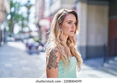 Young Blonde Woman Looking To The Side With Serious Expression At Street