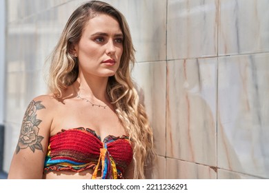 Young Blonde Woman Looking To The Side With Serious Expression At Street