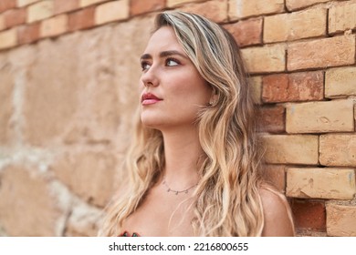 Young Blonde Woman Looking To The Side With Serious Expression At Street