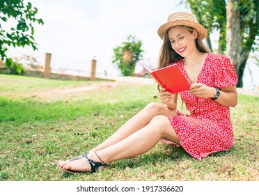 Young Blonde Woman On Vacation Smiling Happy Reading Book Sitting At The Park