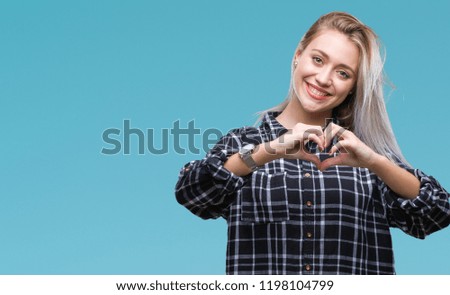 Young blonde woman over isolated background smiling in love showing heart symbol and shape with hands. Romantic concept.