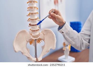 Young blonde woman pysiotherapist pointing to anatomical model of vertebral column at rehab clinic - Powered by Shutterstock