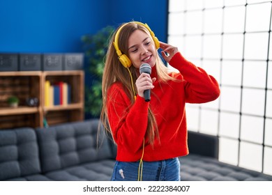 Young Blonde Woman Singing Song And Dancing At Home