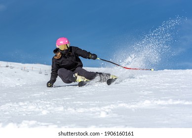 Young Blonde Woman Skiing On A Sunny Day.