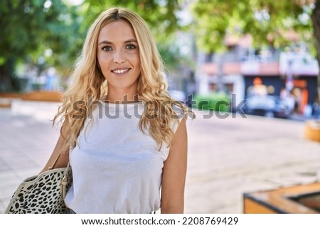 Young blonde woman smiling confident at park